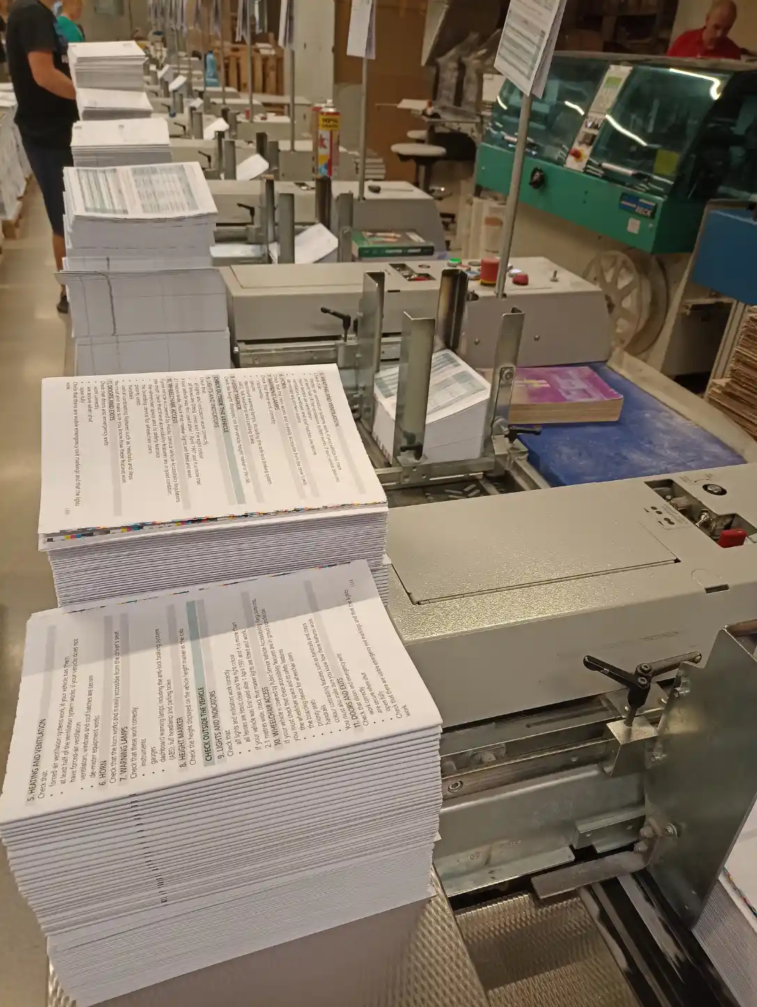 HGV Drivers Diary printed sections moving through a bookbinding production machine.
