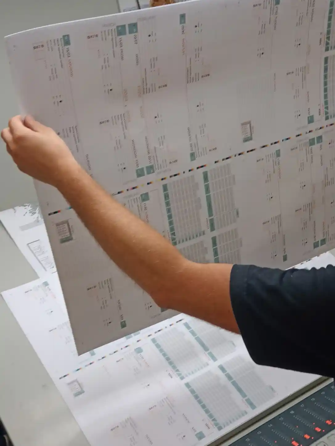 Print operator checking a large HGV Drivers Diary sheet during production.
